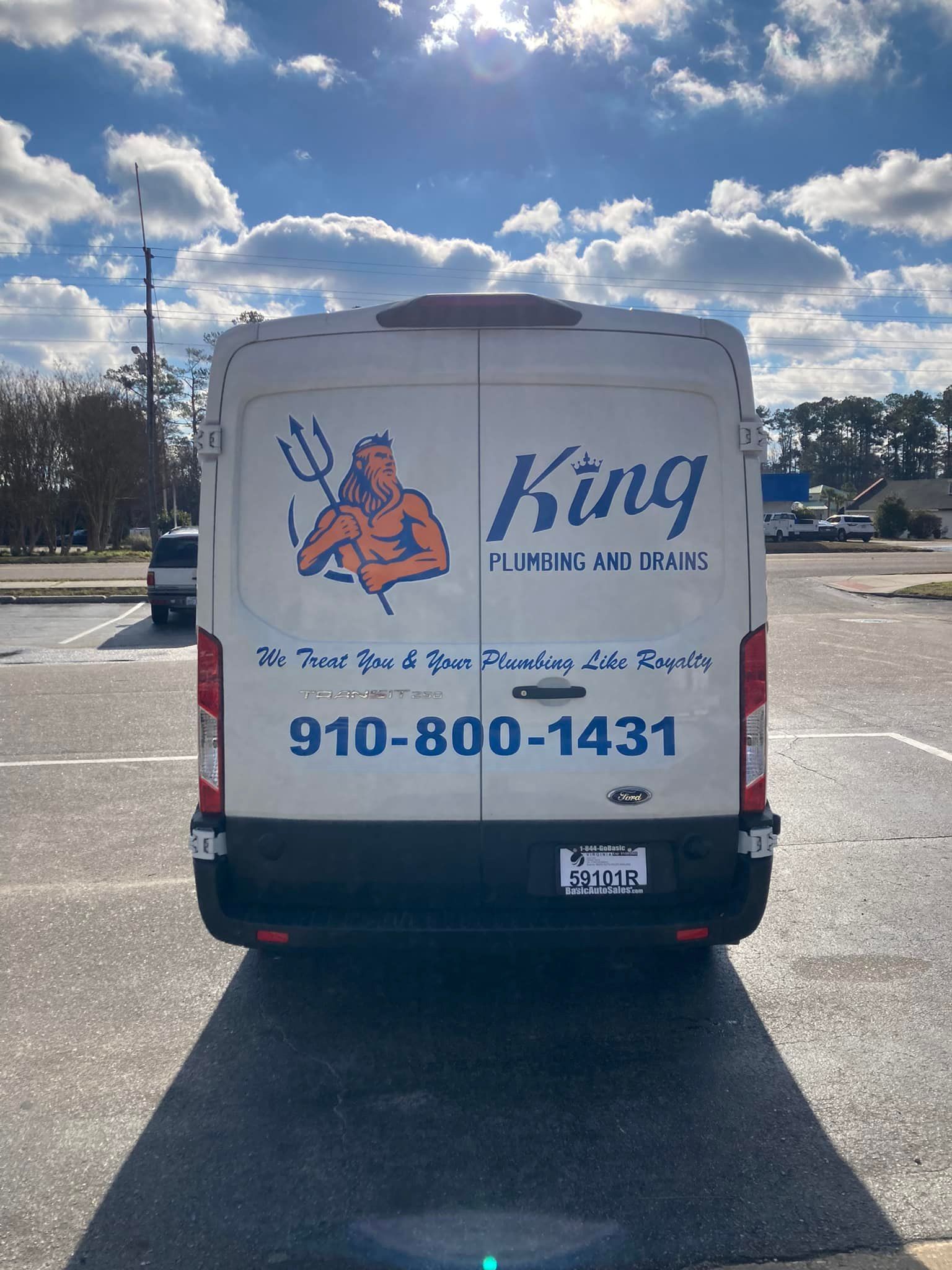 A white van with a devil on the back is parked in a parking lot.