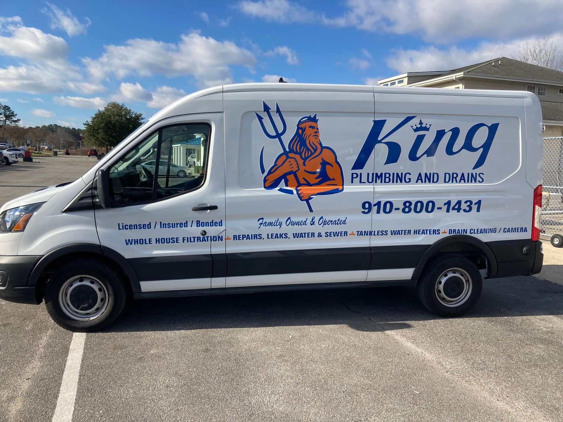 A king plumbing and drains van is parked in a parking lot.