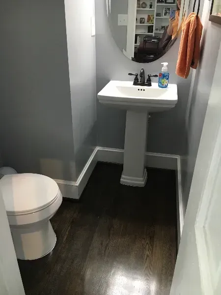 A bathroom with a toilet a sink and a mirror