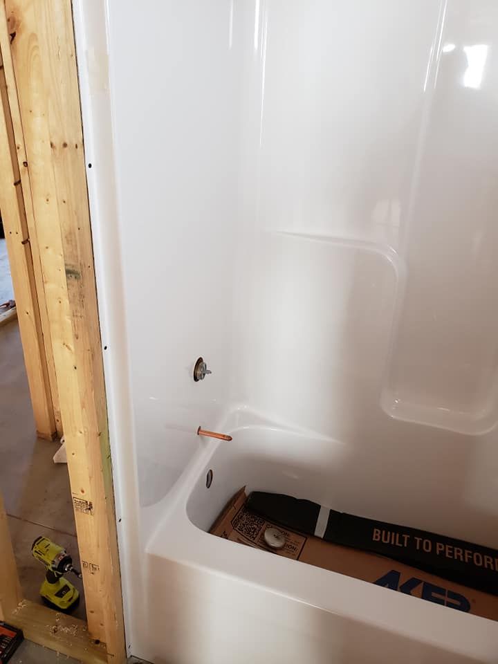 A bathtub is being installed in a bathroom under construction.