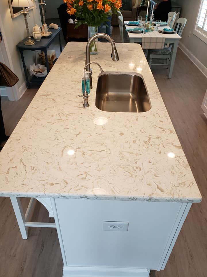 A kitchen island with a stainless steel sink and faucet.