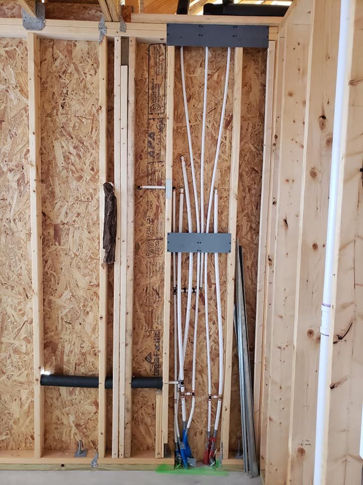 A wooden wall with a bunch of pipes hanging from it.