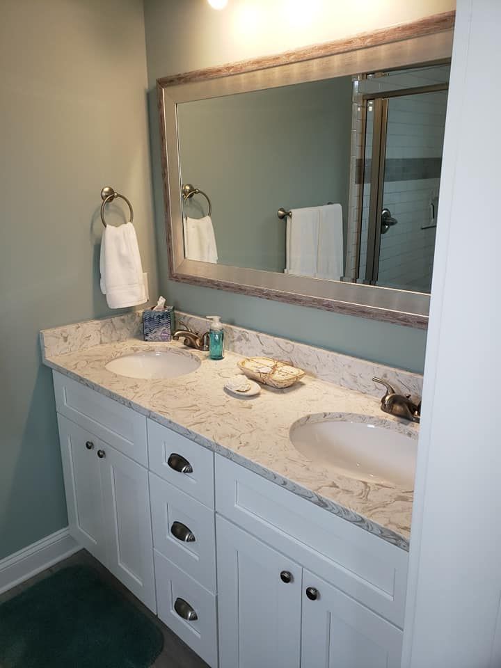 A bathroom with two sinks and a large mirror.