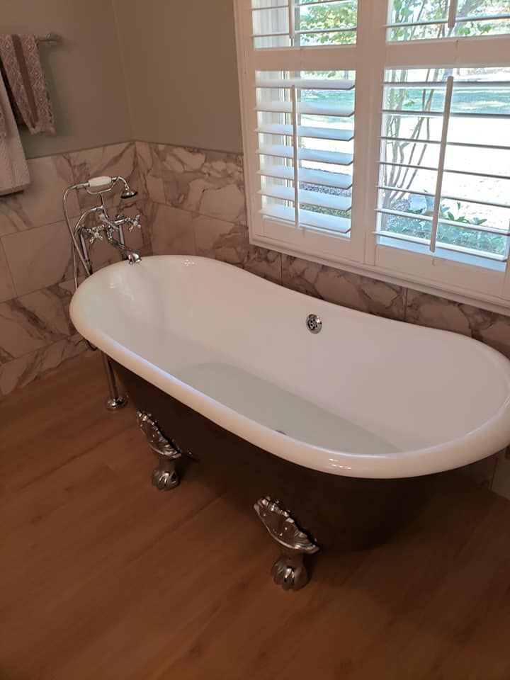 A bathtub is sitting in a bathroom next to a window.