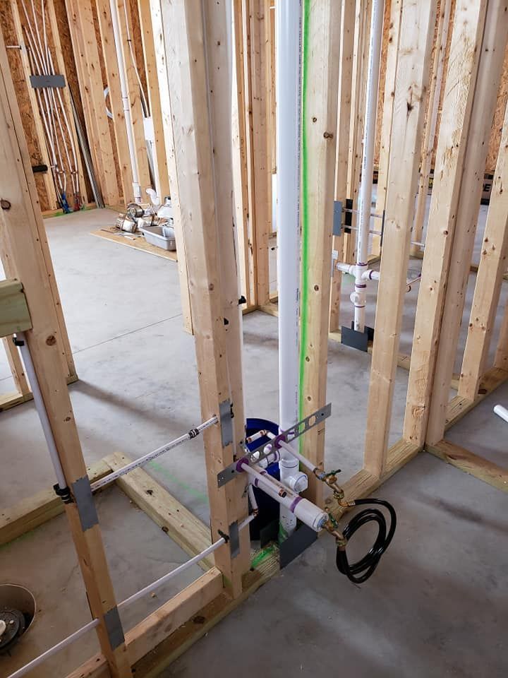 A pipe is being installed in a house under construction.