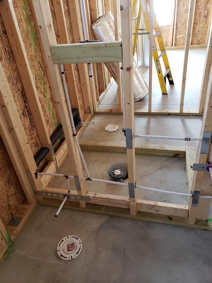 A bathroom under construction with a ladder in the background.