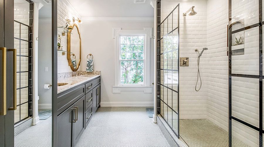 A bathroom with two sinks and a walk in shower.