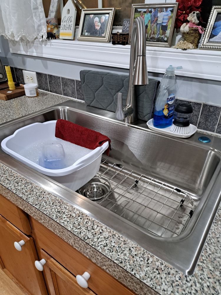 A kitchen sink with a stainless steel faucet and a white bowl on the counter.