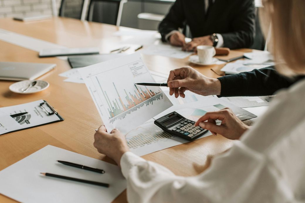A group of people are sitting at a table looking at a graph.