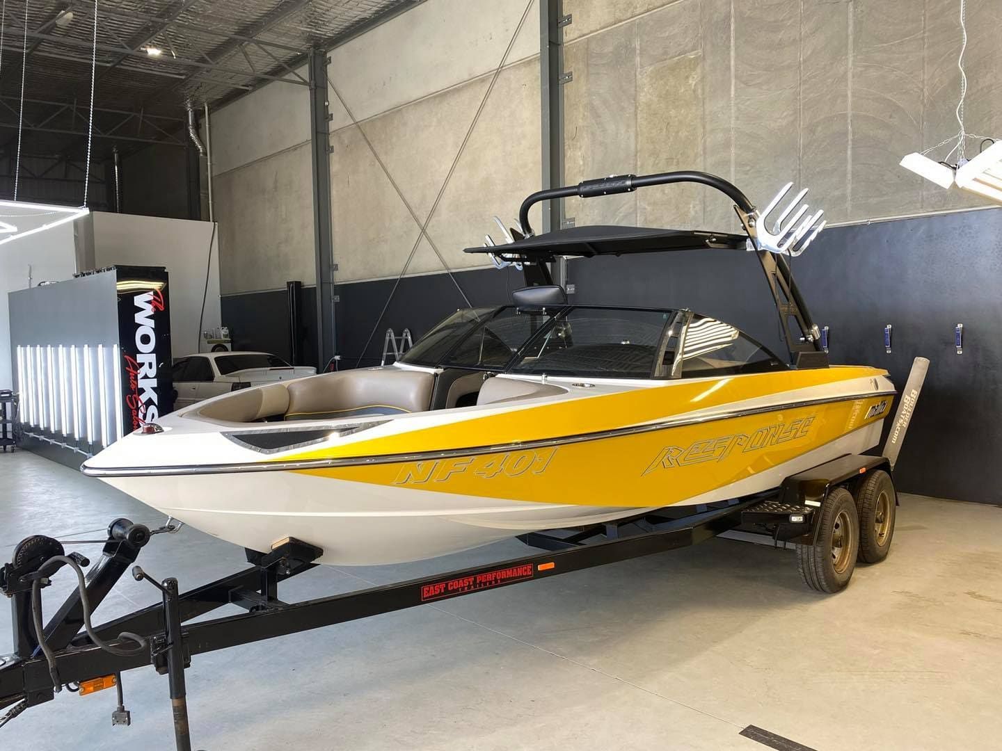 A Yellow And White Boat Is Parked On A Trailer In A Warehouse — The Works Auto Salon In East Bendigo, VIC