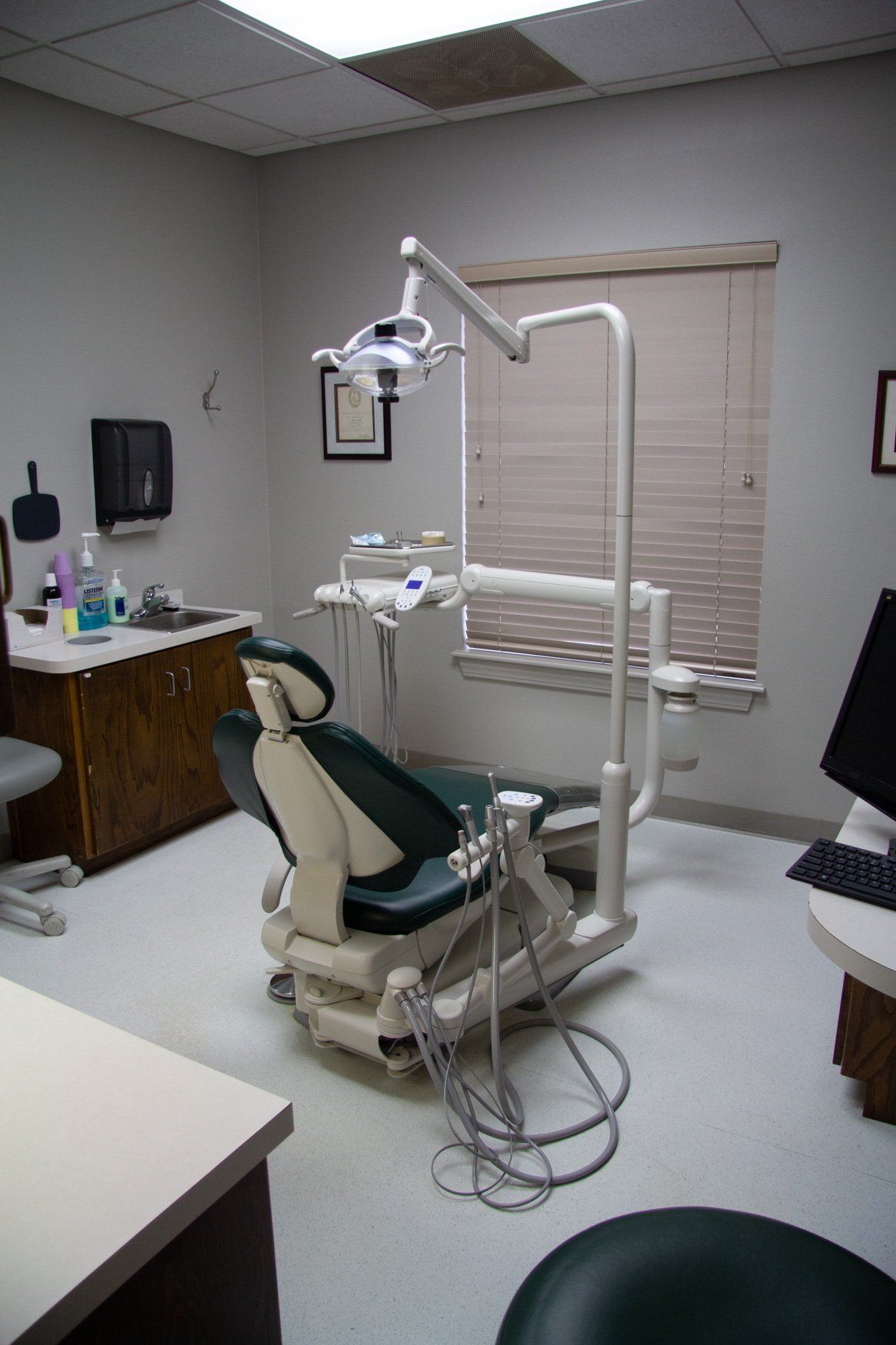 A dental office with a dental chair and a computer