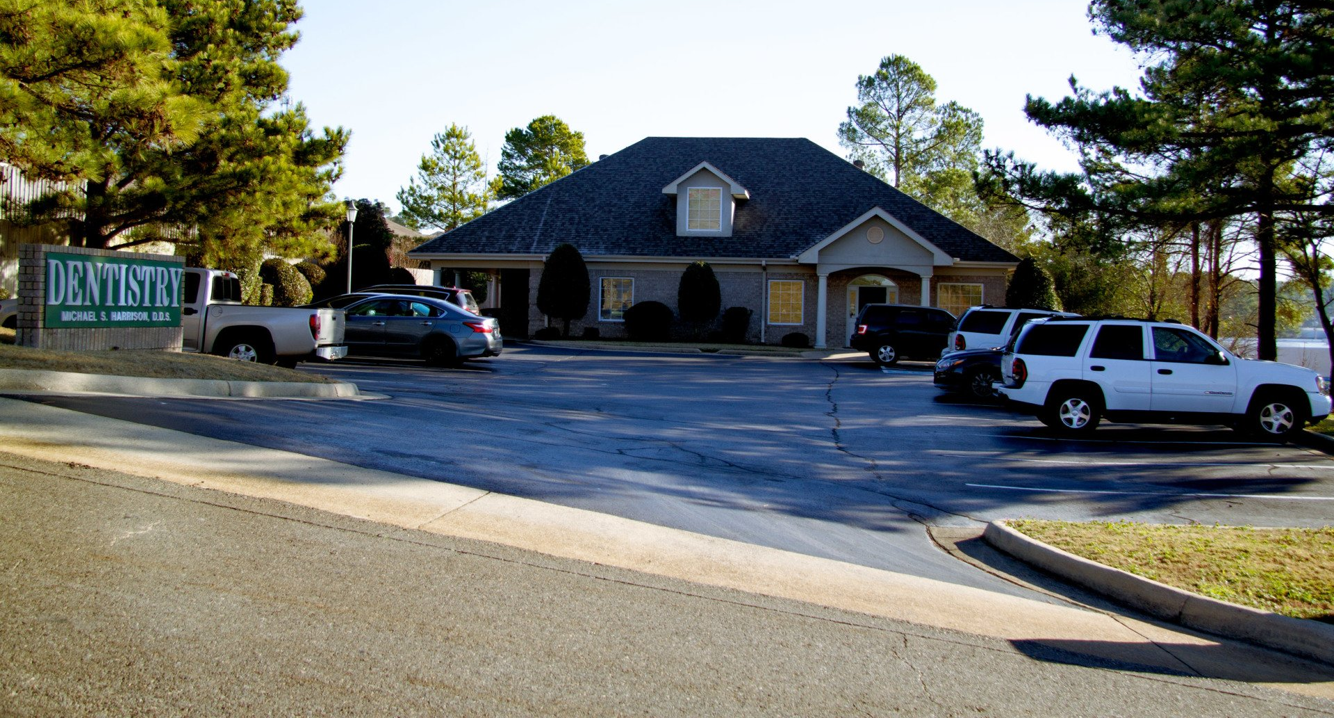 A dental office with cars parked in front of it