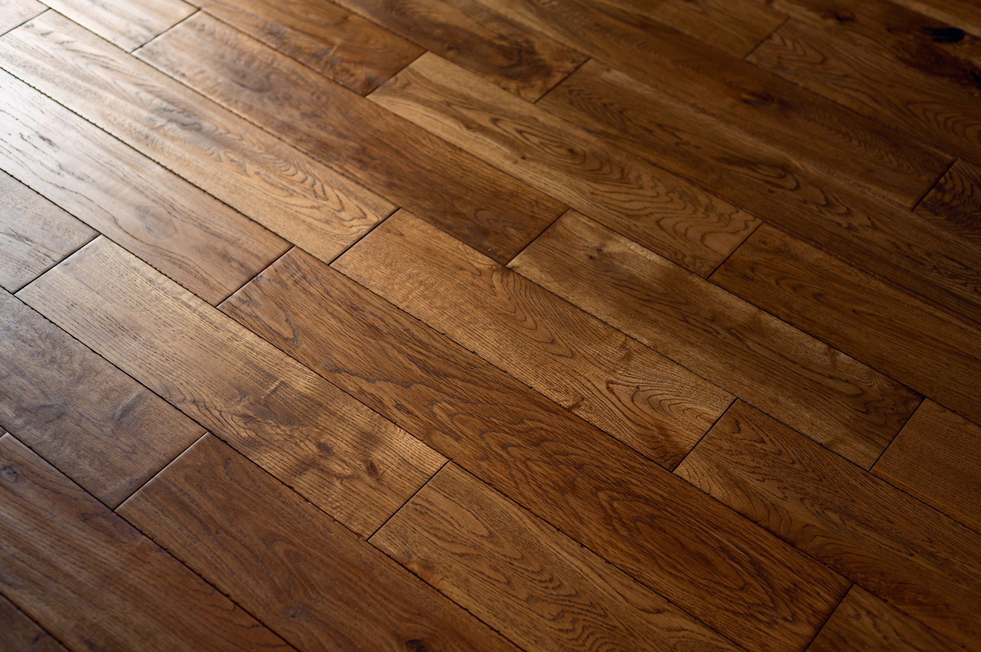 Wooden hardwood floorboards, brown, diagonal pattern, texture visible.