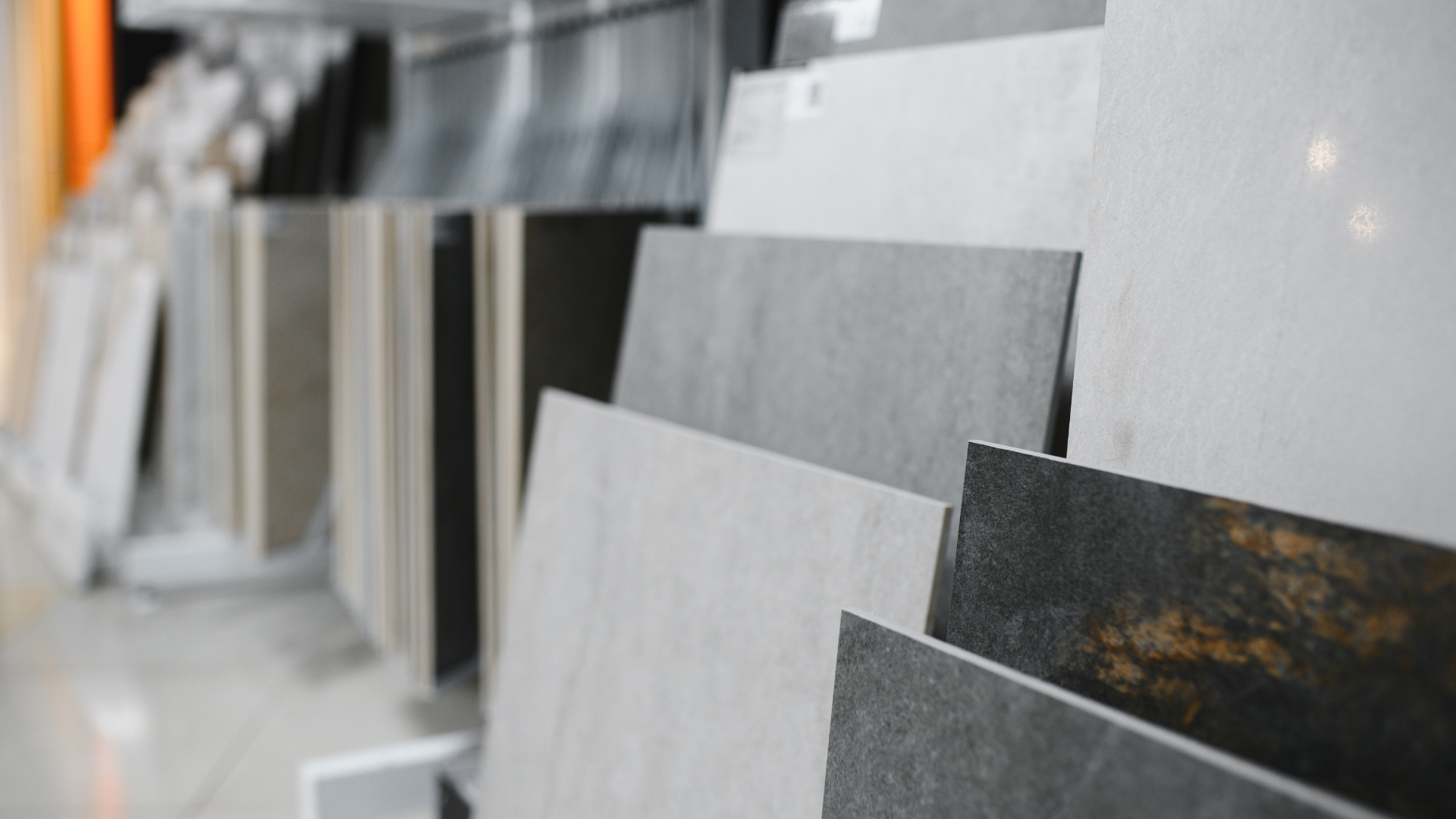 Display of various gray and white ceramic tiles in a store.