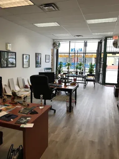 Interior of an office with desks, chairs, framed art, and large windows with business signage.