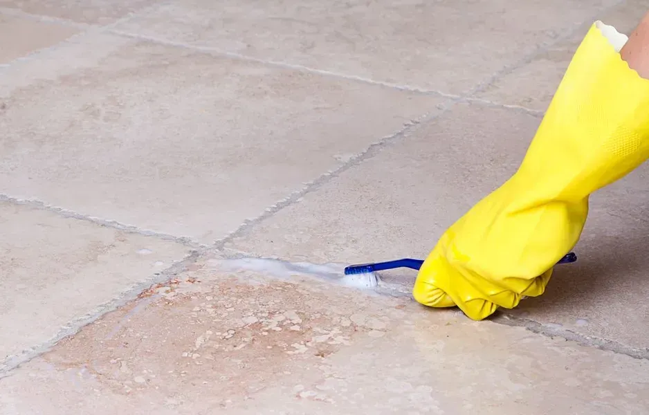 Hand in Yellow Glove Scrubs Tile Grout With Toothbrush — Phil Lindfield's Big Red Carpet Cleaning In Hallidays Point, NSW