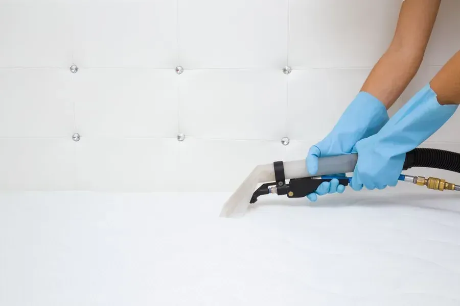 Person in Blue Gloves Cleaning a White Tufted Headboard — Phil Lindfield's Big Red Carpet Cleaning In Hallidays Point, NSW