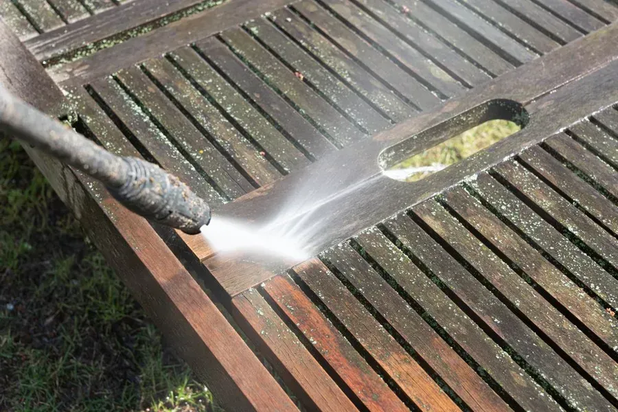 Pressure Washing a Weathered Wooden Table Outdoors — Phil Lindfield's Big Red Carpet Cleaning In Forster, NSW