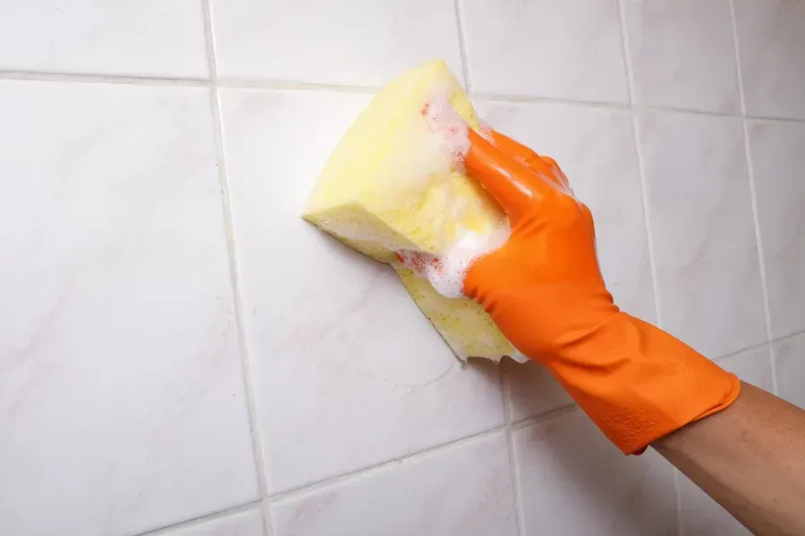 Hand in Orange Glove Cleaning White Tile — Phil Lindfield's Big Red Carpet Cleaning In Gloucester, NSW