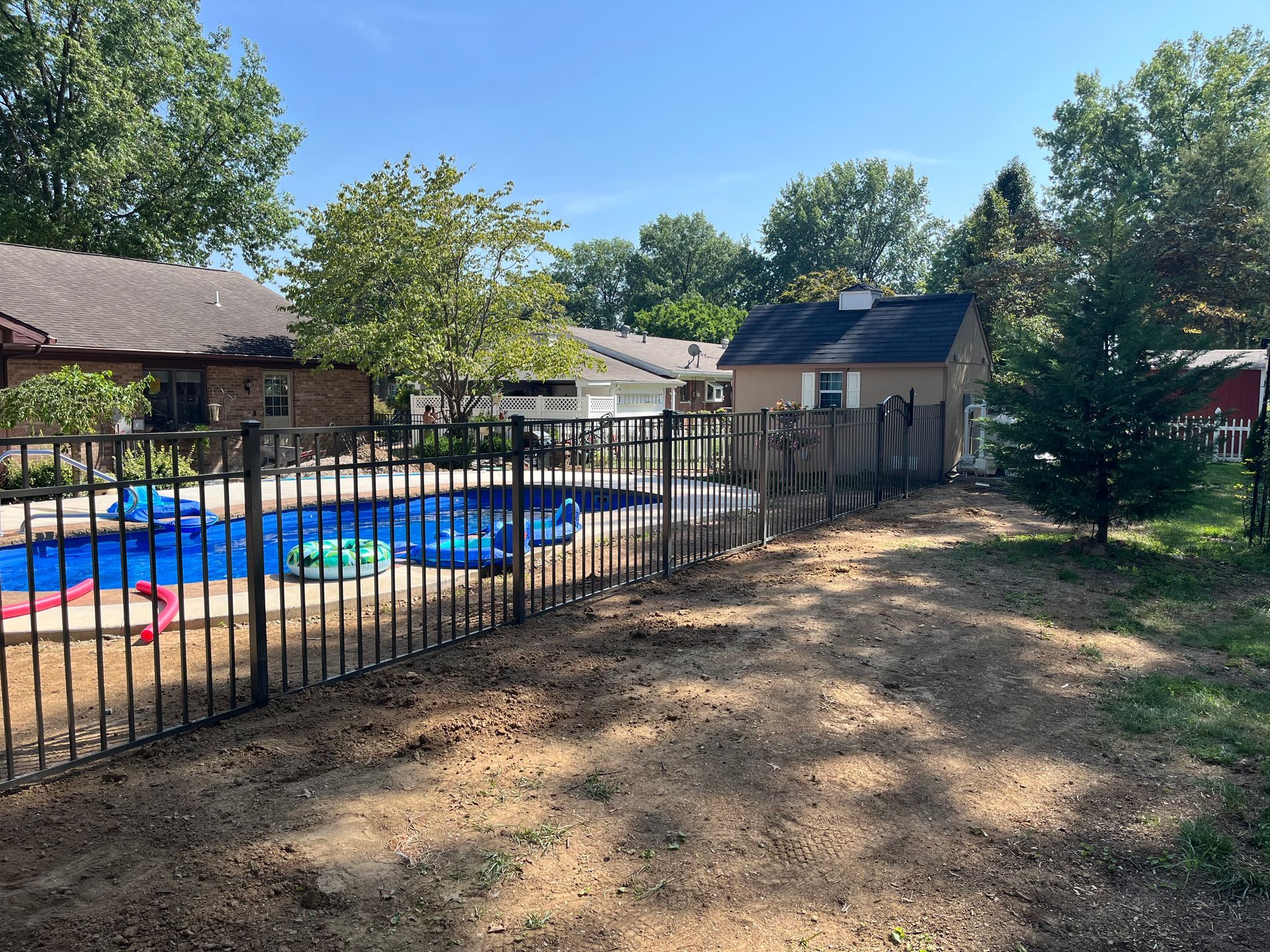 A Fence Surrounds A Swimming Pool In A Backyard — Troy, IL — Osborne Fence LLC