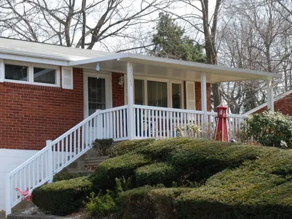 A brick house with a white porch and stairs