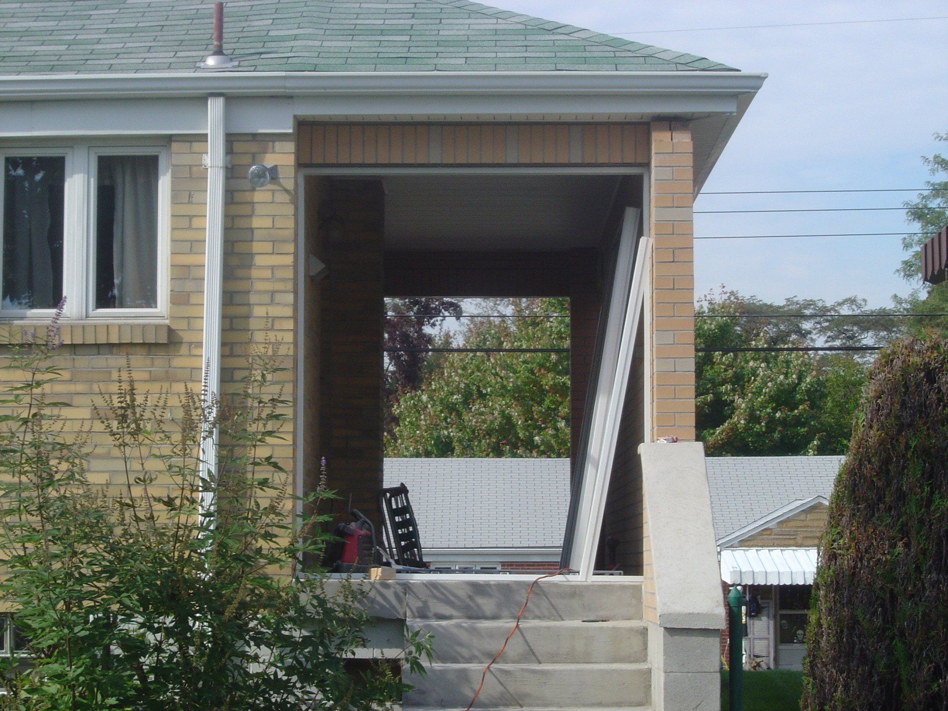A brick house with stairs leading up to a porch
