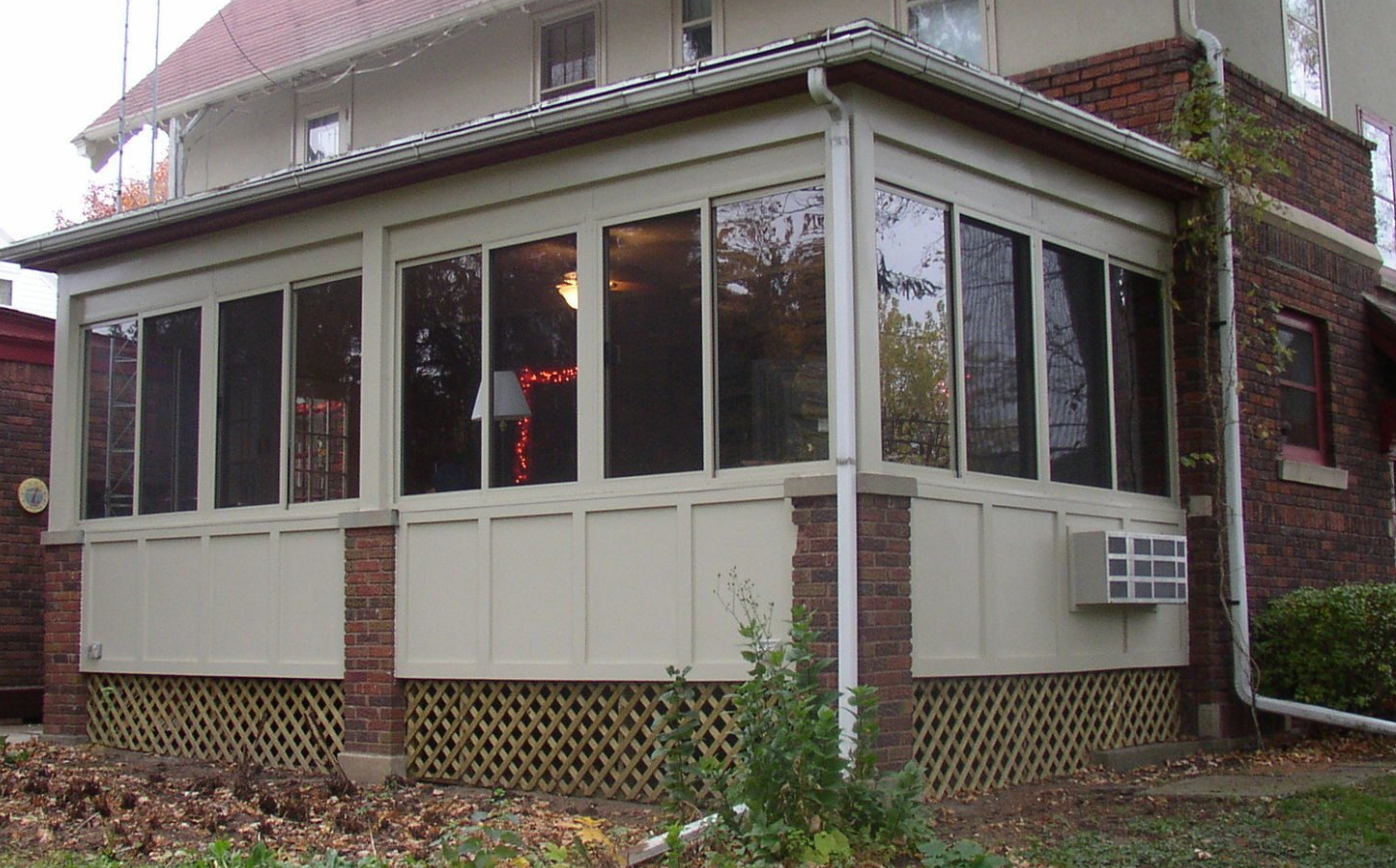 A house with a screened in porch with lots of windows
