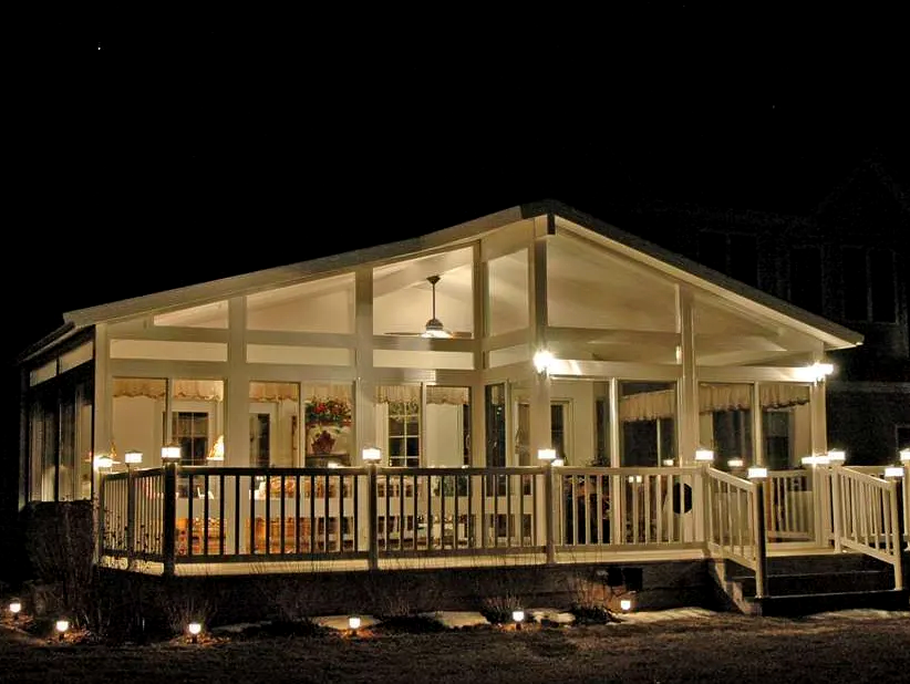 A house with a large porch is lit up at night