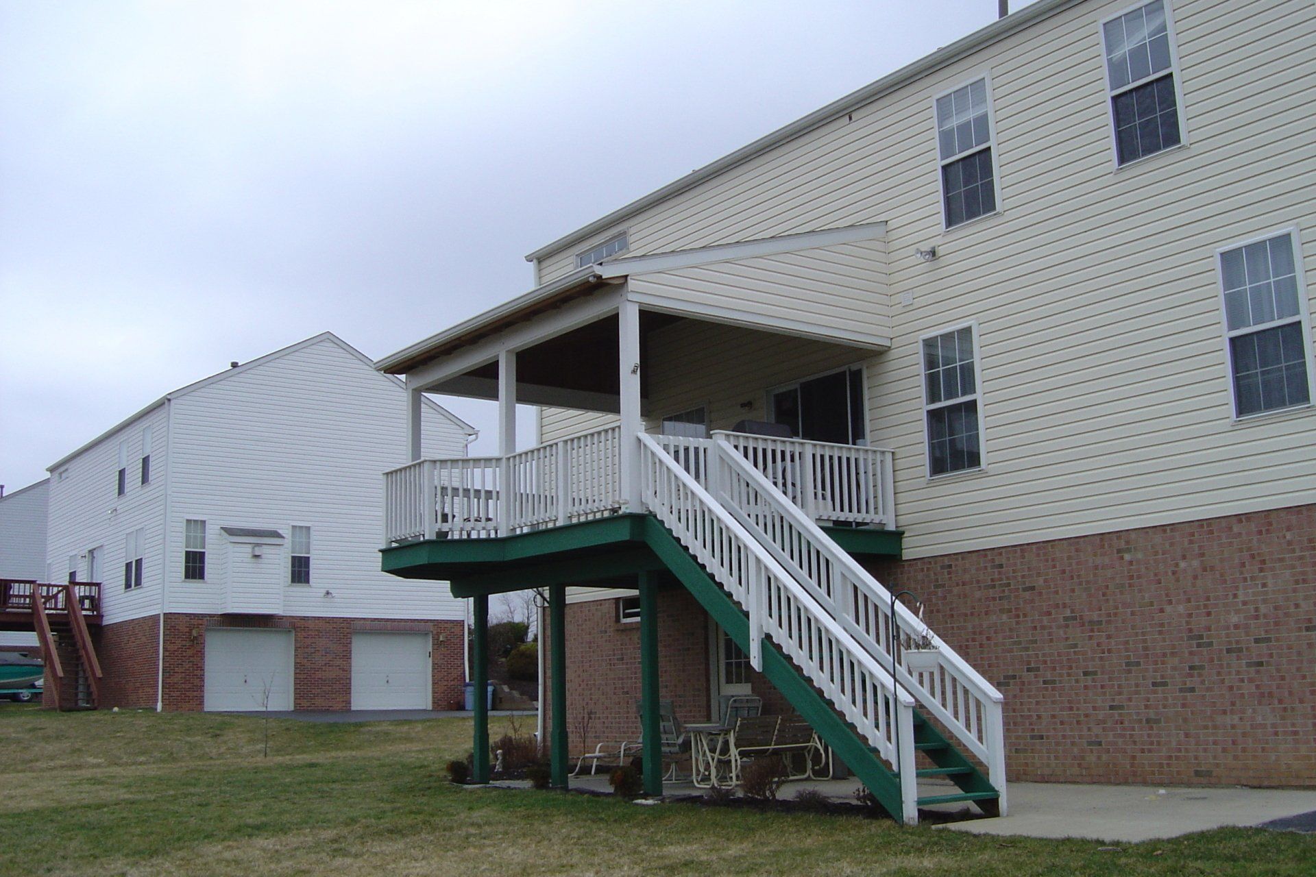 A house with a green deck and white stairs
