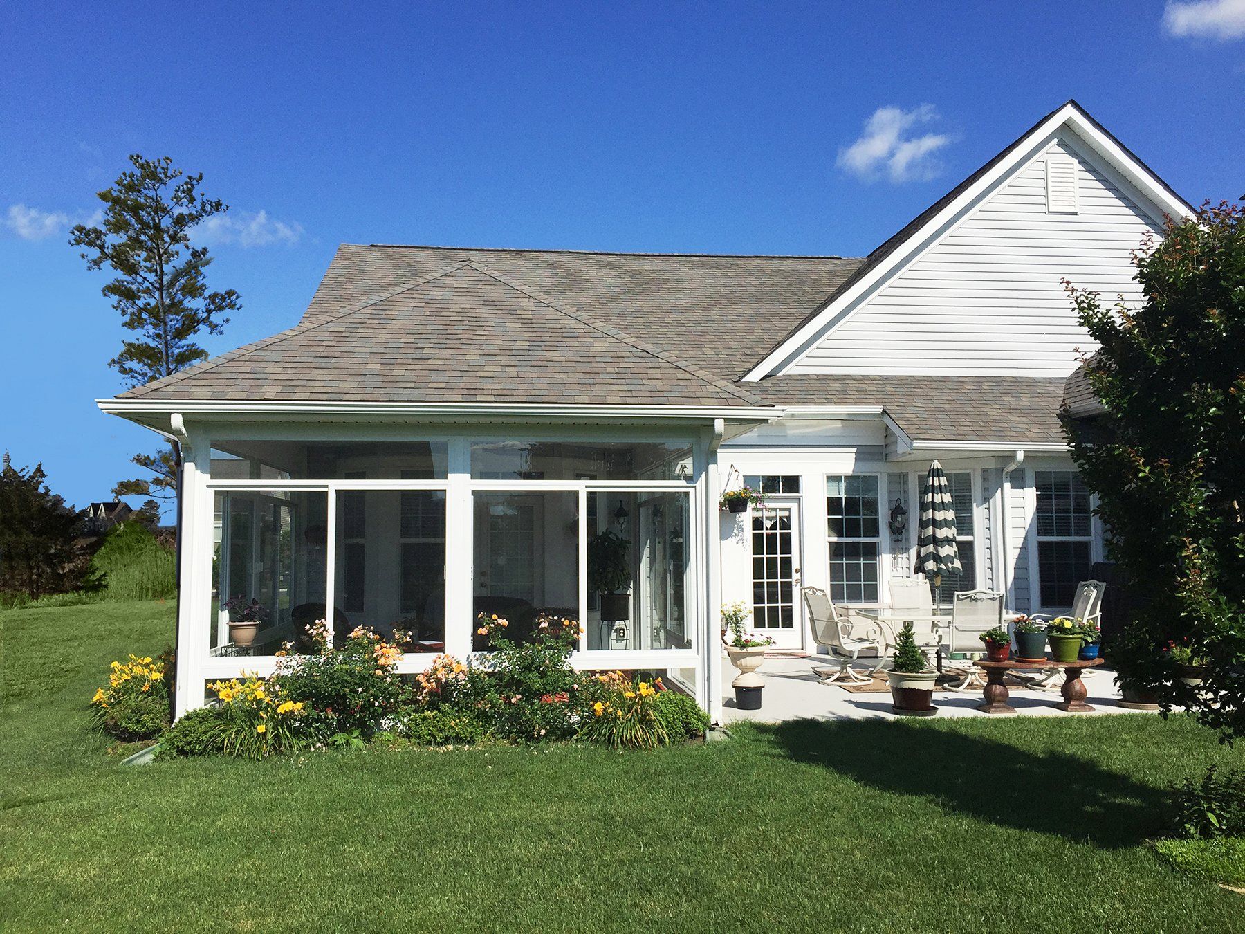 A small white house with a screened in porch