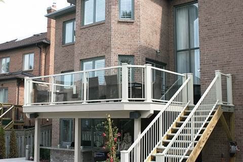 A large brick house with a deck and stairs