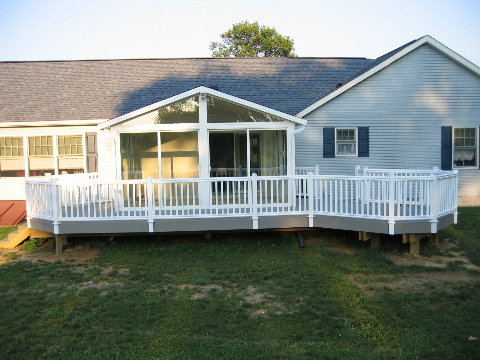 A house with a screened in porch and a white deck