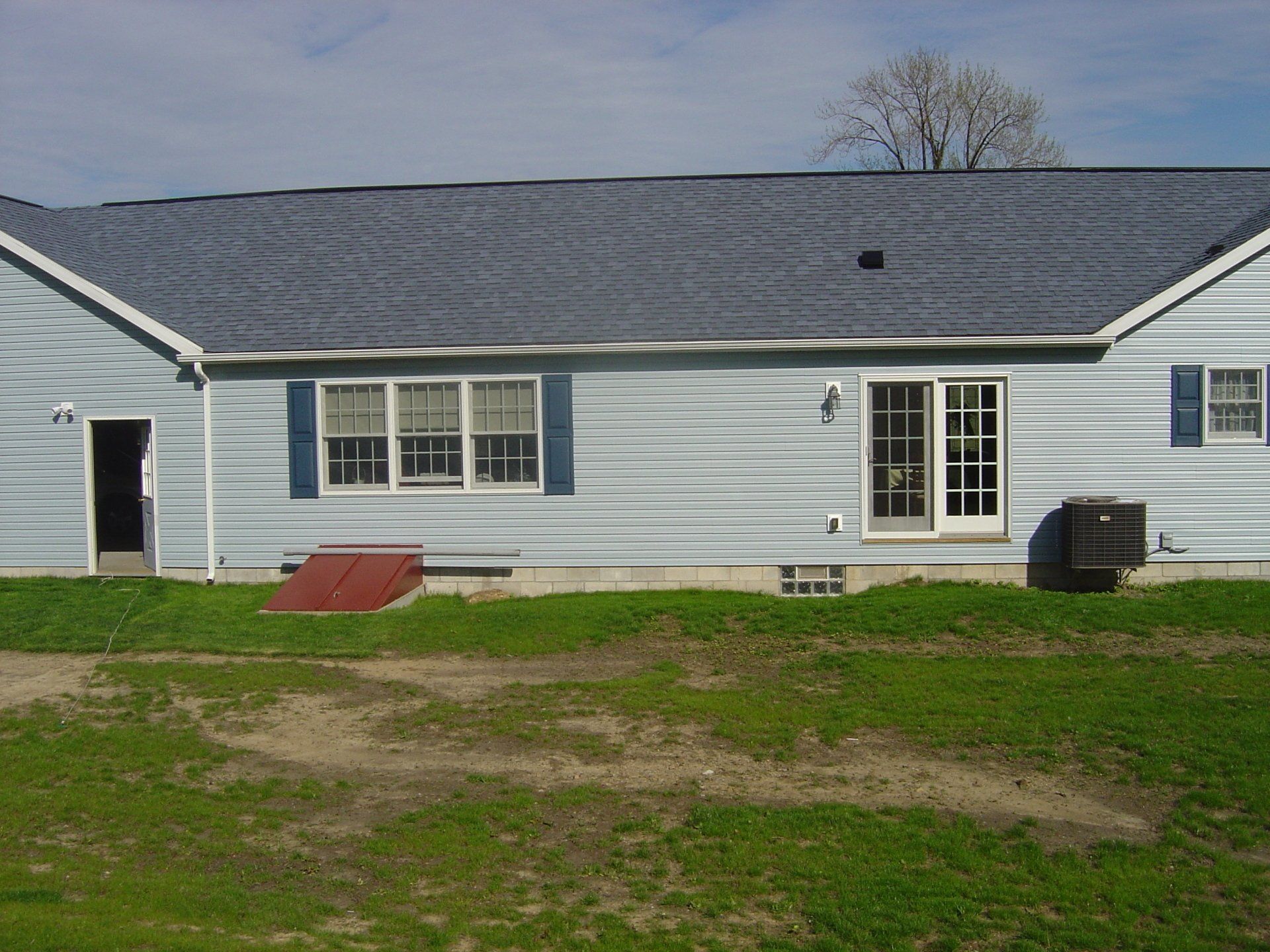 A blue house with a gray roof and blue shutters