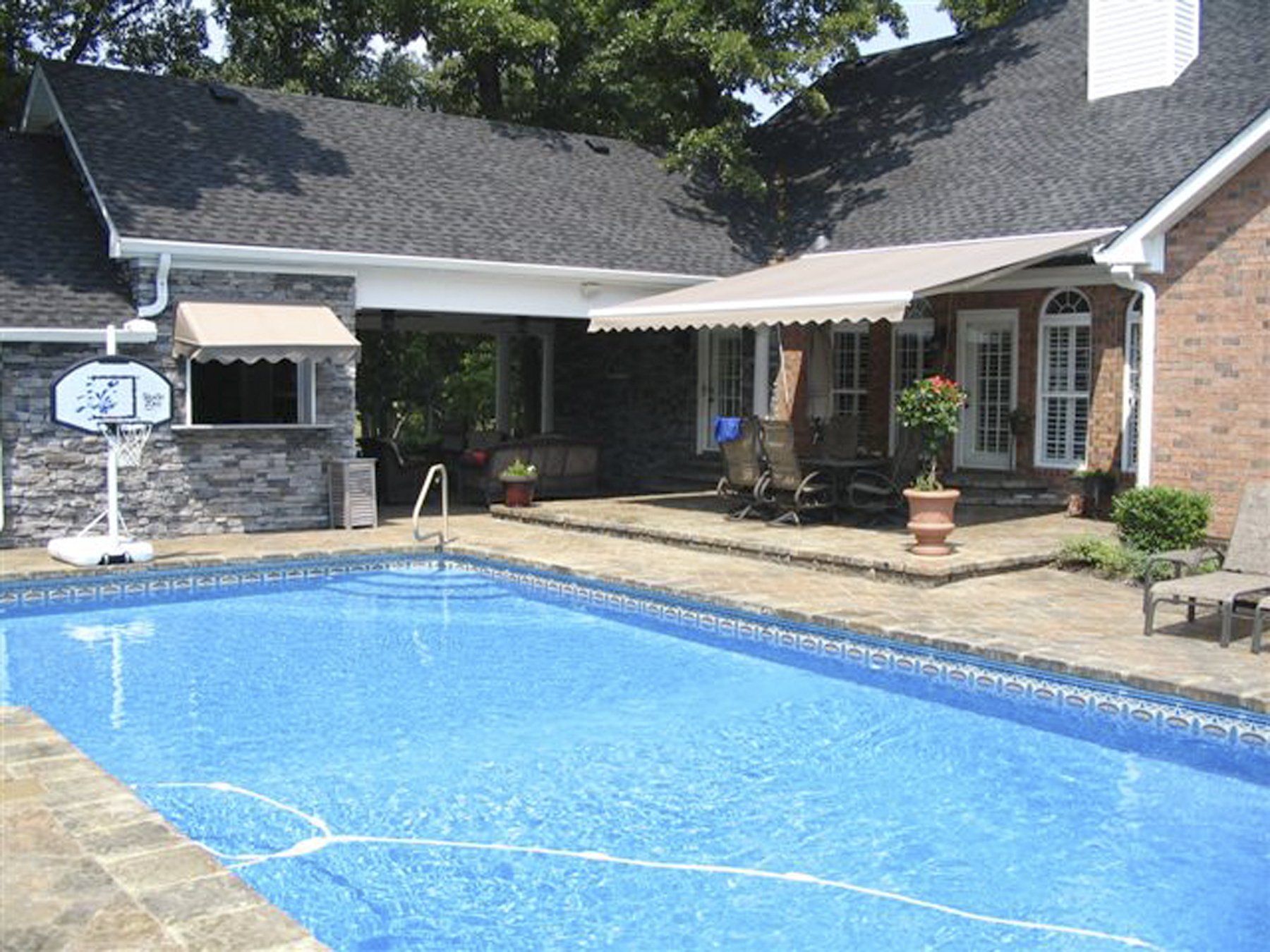 A house with a large swimming pool in front of it