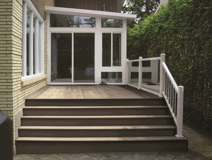 A wooden deck with stairs and a white railing