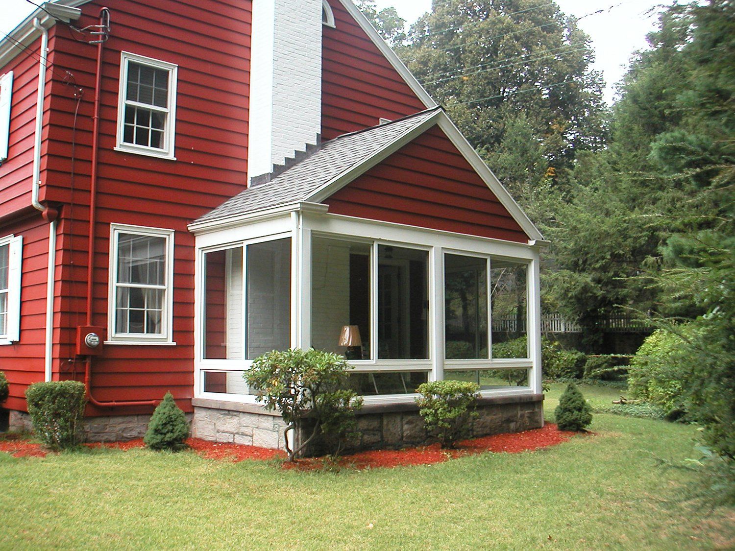 A large red house with a screened in porch