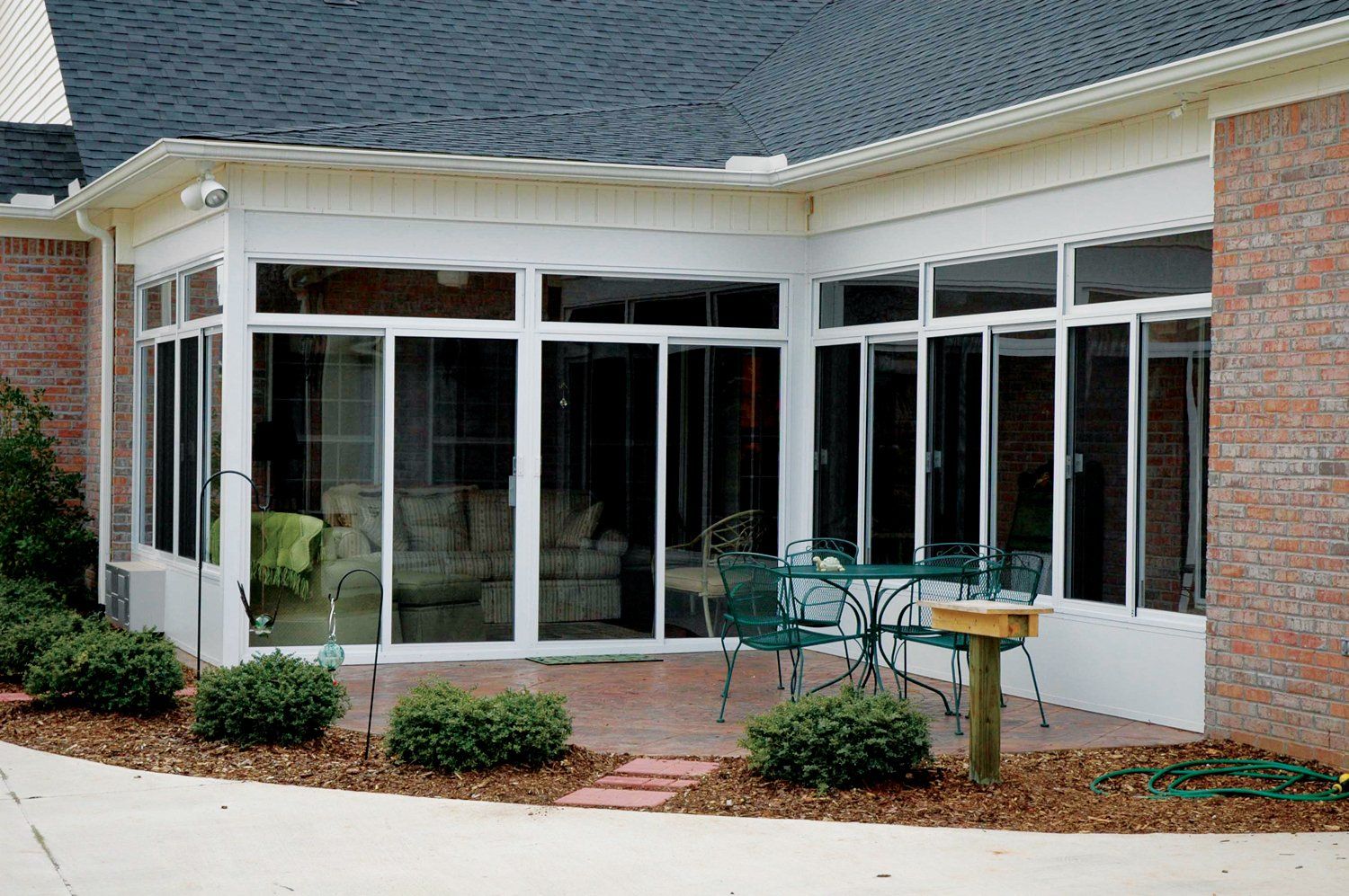 A screened in porch with a table and chairs