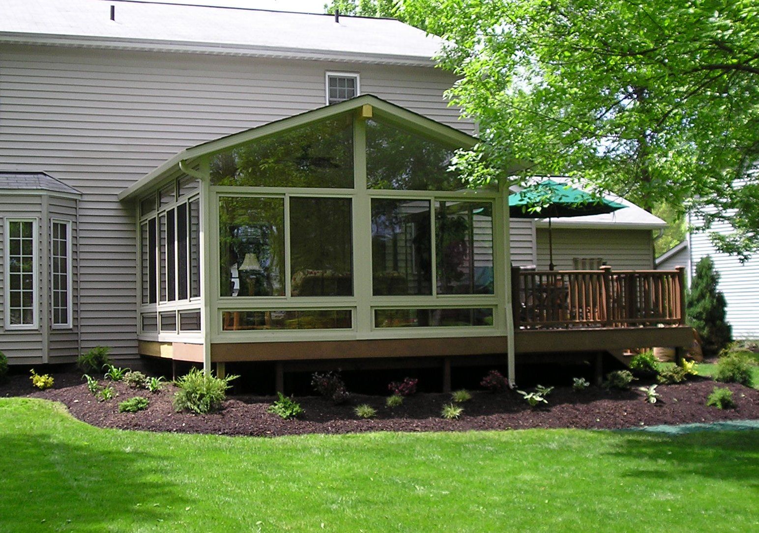 A house with a screened in porch and a deck