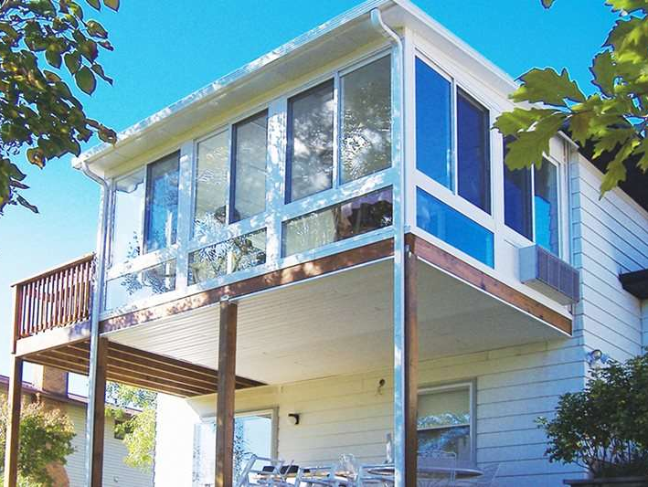 A white house with a balcony and blue windows
