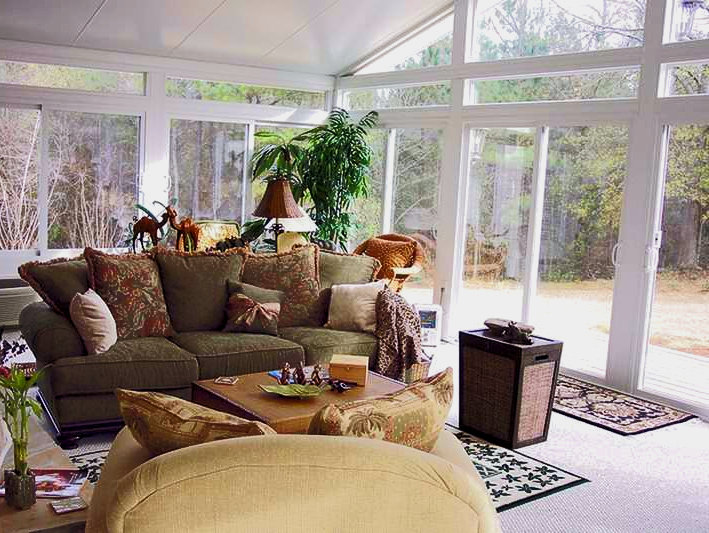 A living room with a green couch and yellow chairs
