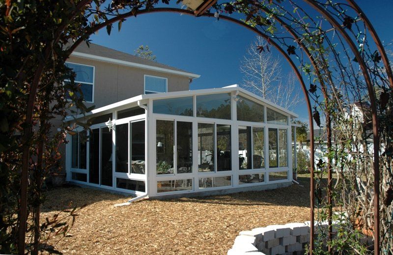 A house with a sunroom in the backyard