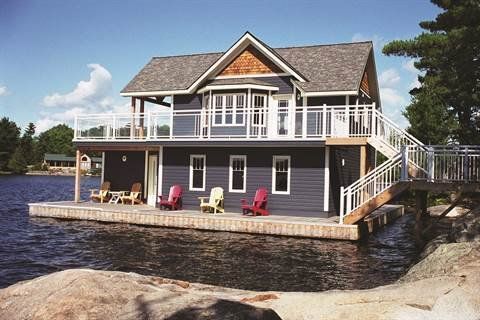 A large house is sitting on top of a body of water.