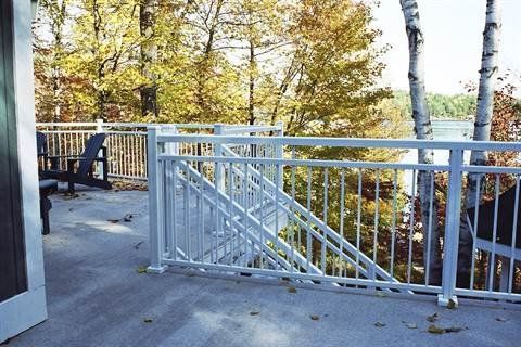 A white railing on a balcony overlooking a lake