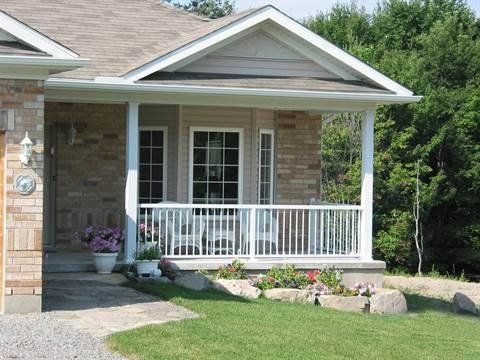 A brick house with a porch and a white railing