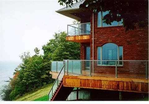 A brick house with a glass balcony and stairs