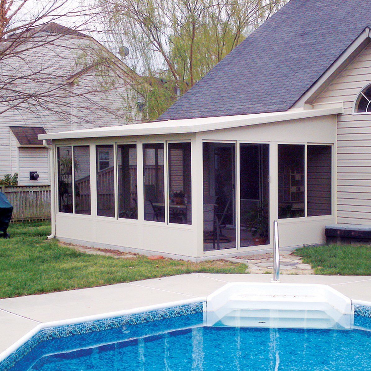 A house with a screened in porch next to a swimming pool