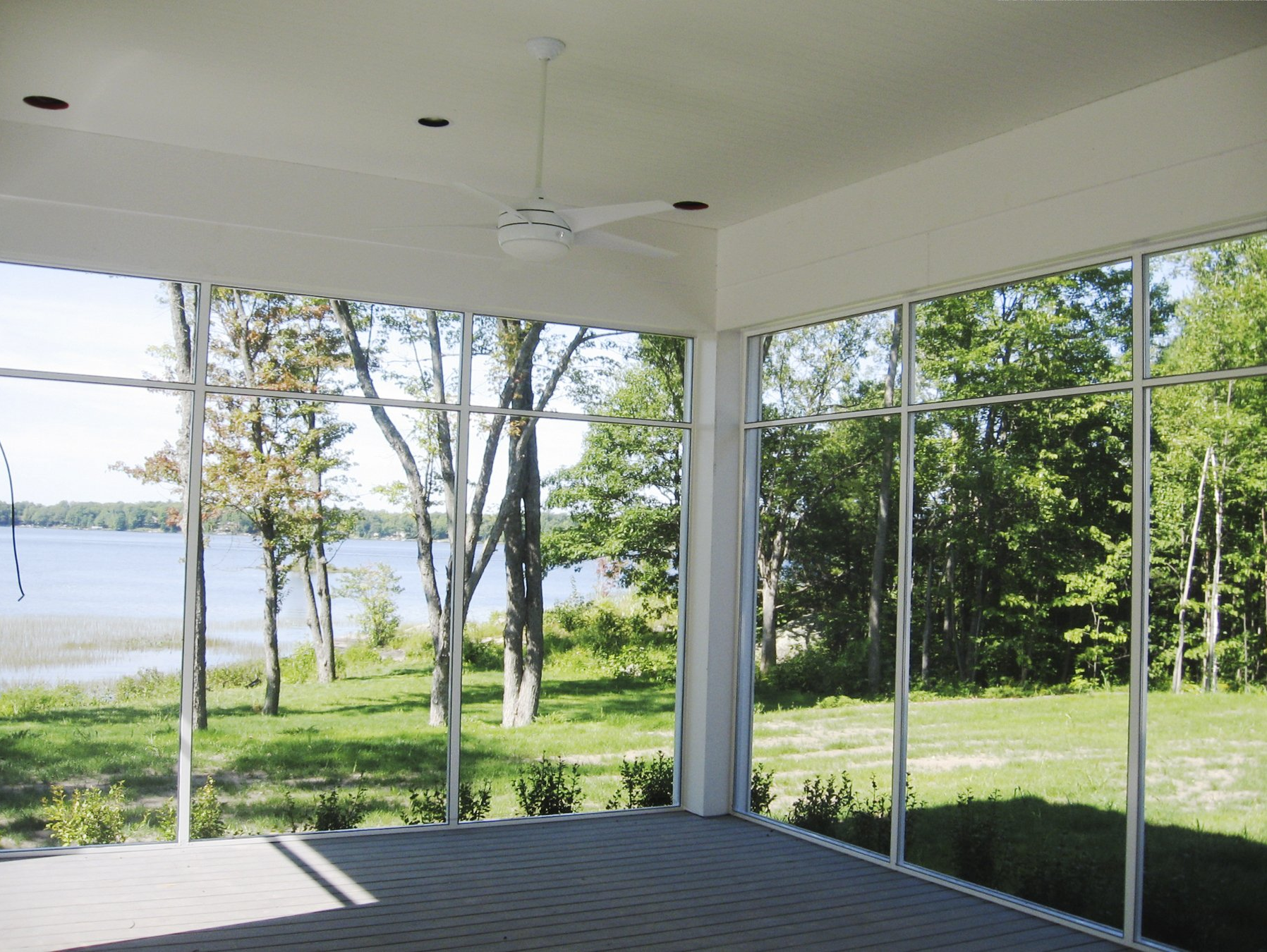 A screened in porch with a view of a lake