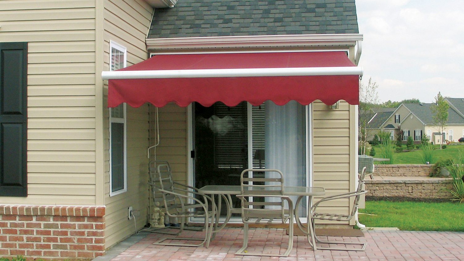 A patio with a red awning and a table and chairs