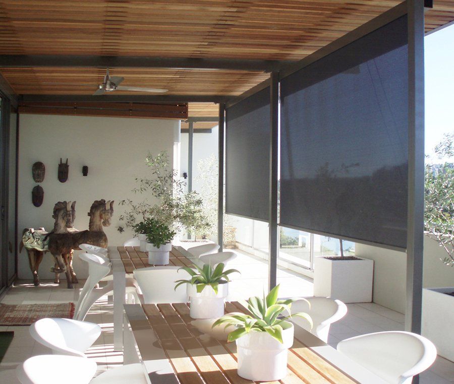 A patio with a table and chairs and potted plants
