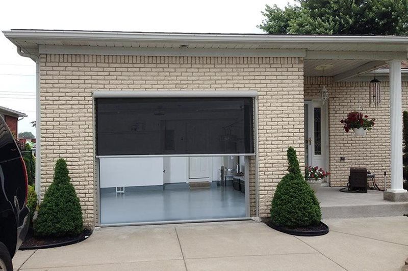 A brick house with a screened in garage door
